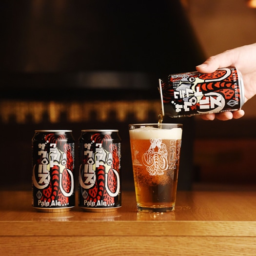 軽井沢ビールクラフトザウルスペールエールの缶が２缶とグラスが並び、グラスにビールが注がれている画像。