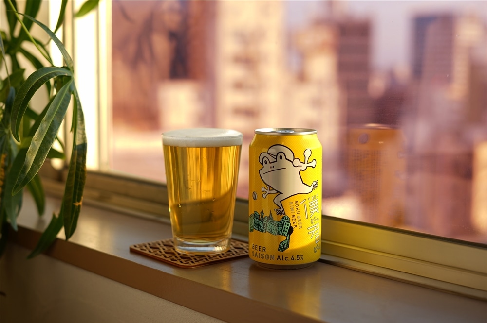 都会のマンションの一室の窓際に、僕ビール君ビールの缶とグラスが並んでいる様子