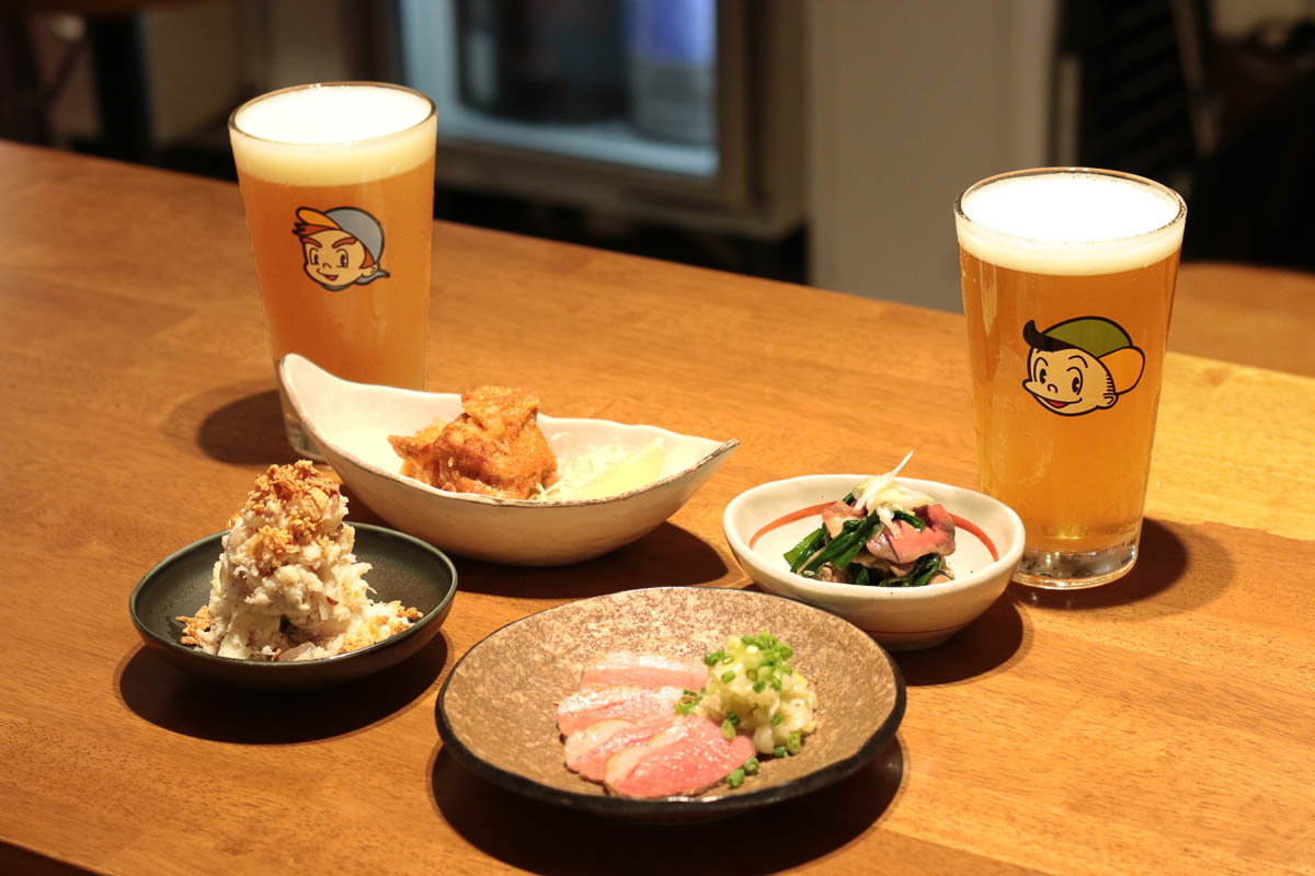 立ち飲みビールボーイ渋谷パルコ店のフードメニュー4種とクラフトビール２種がテーブルの上に並んでいる様子