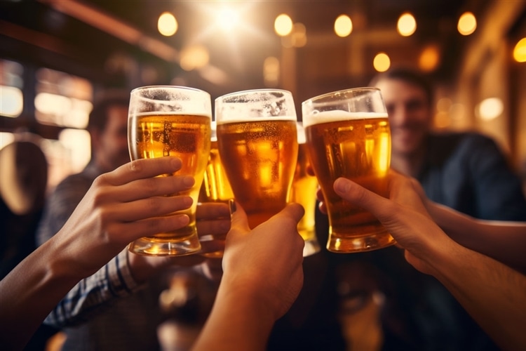 ビアパブで5人の人がビールグラスで乾杯している様子
