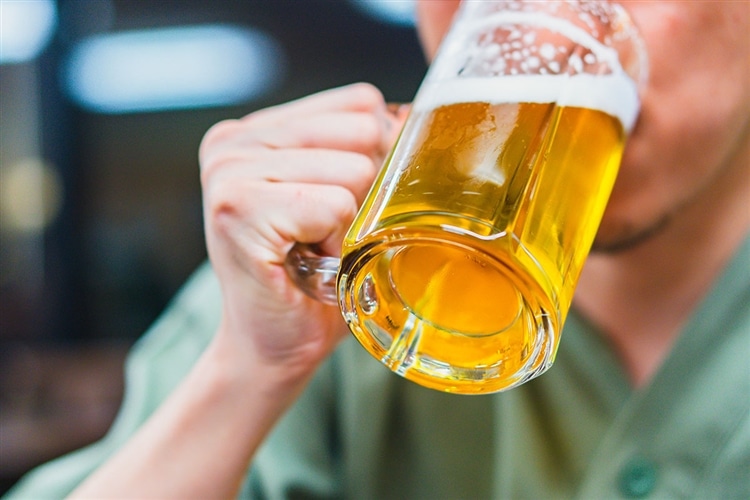 風呂上がりの男性が、ジョッキに注がれたビールを飲んでいる画像