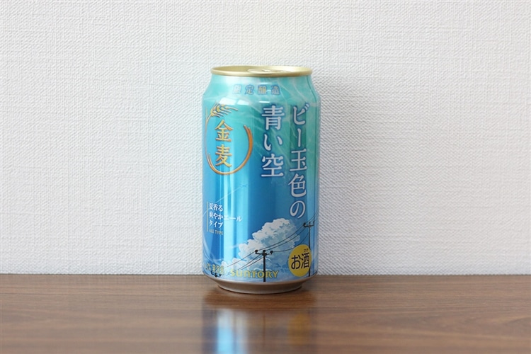 サントリーが販売する、金麦＜ビー玉色の青い空＞の缶がテーブルの上に置かれている画像
