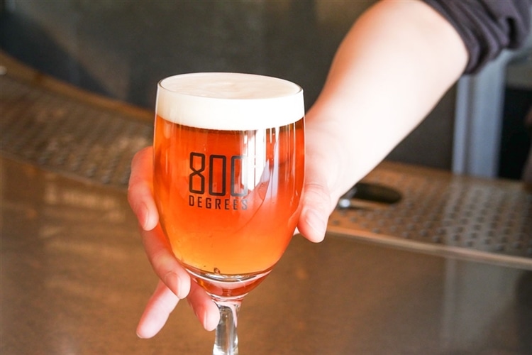 800°DEGREES CRAFT BREW STANDオリジナルビールをグラスに注いでいる画像
