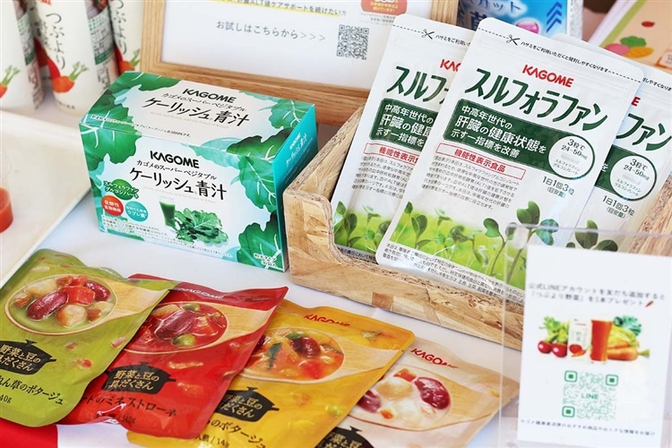 カゴメの製品（青汁、スープの素）がテーブルの上に並んでいる画像