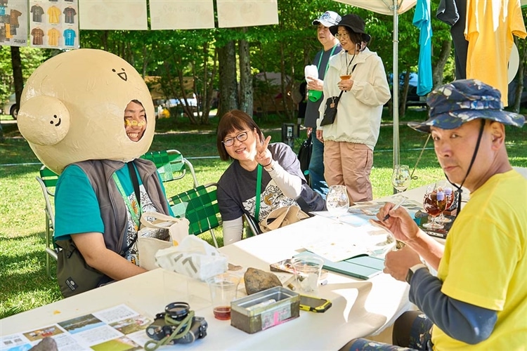 「よなよなエールの超宴2024 in 新緑の北軽井沢」で参加者と談笑するヤッホーブルーイング男性スタッフの写真