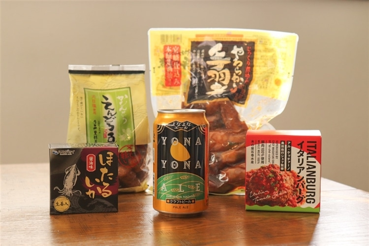 よなよなエールの缶と、日本百貨店のおつまみ4種が机の上に並んでいる様子