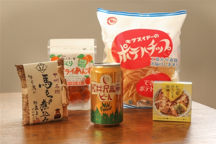 軽井沢高原ビールワイルドフォレストの缶と、日本百貨店のおつまみ4種が机の上に並んでいる様子
