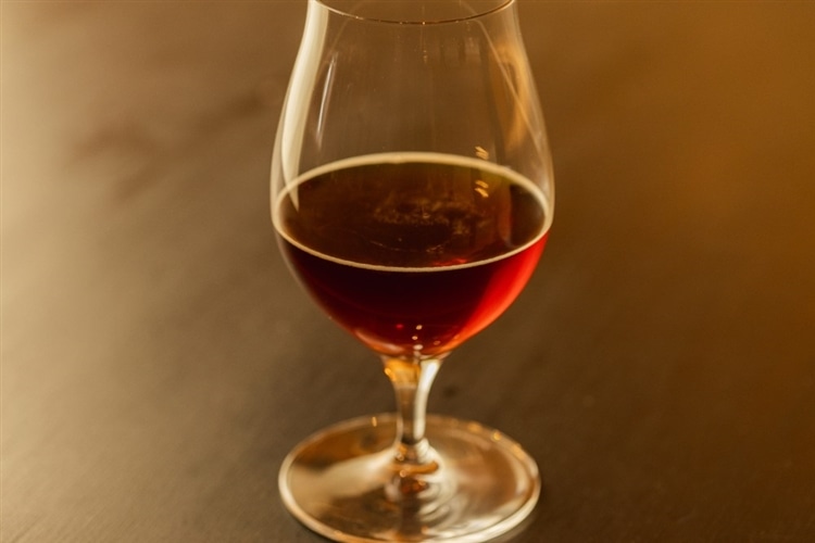 チューリップグラスに注がれたバーレイワインがテーブルの上に置かれている画像