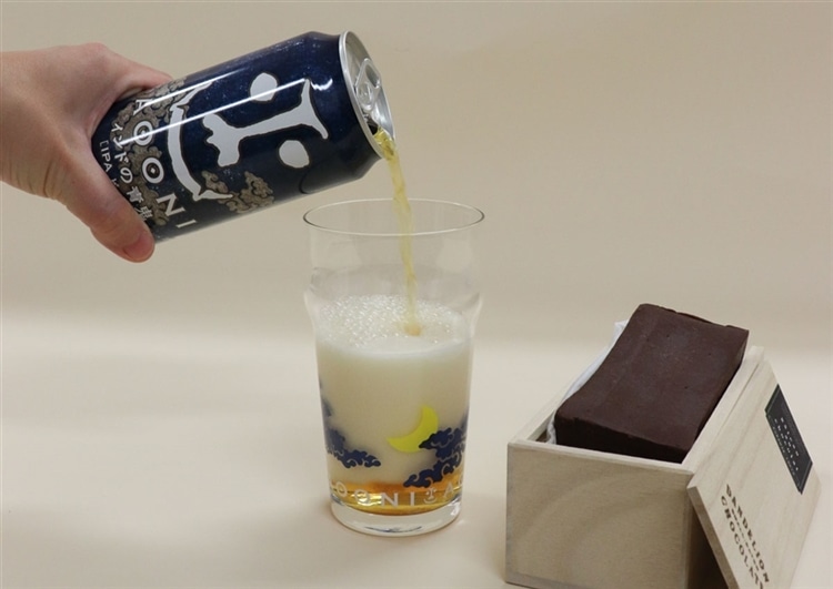 インドの青鬼をグラスに注いでいる様子。横にはダンデライオン・チョコレートのガトーショコラが並んでいる