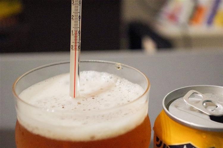 グラスに注がれたビールに温度計が刺さっている様子