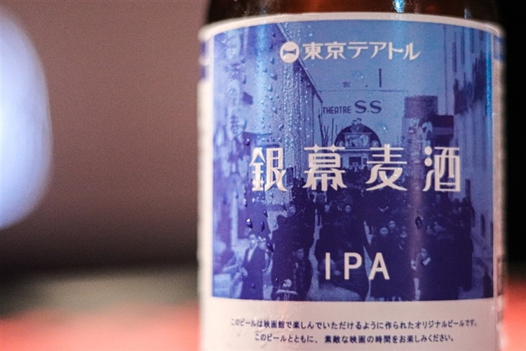 テアトル新宿のオリジナルビール「銀幕麦酒」のパッケージデザインにフォーカスしている様子