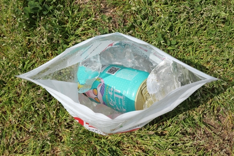 芝生の上に置いたロックアイスの袋の中に「正気のサタン」を入れている様子