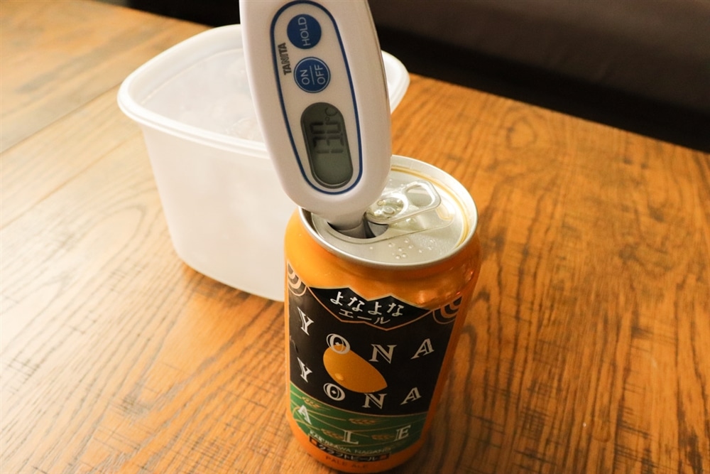 温度計でビールの液温を測り、13℃を示している様子