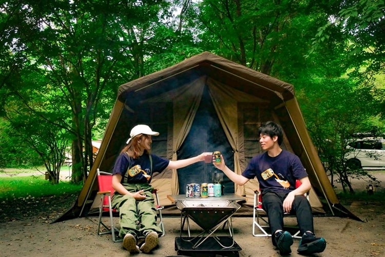 北軽井沢キャンプ場でクラフトビールで乾杯をする男女