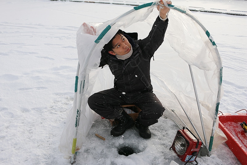 氷上でワカサギ釣りをするために、ドームテントを広げている様子