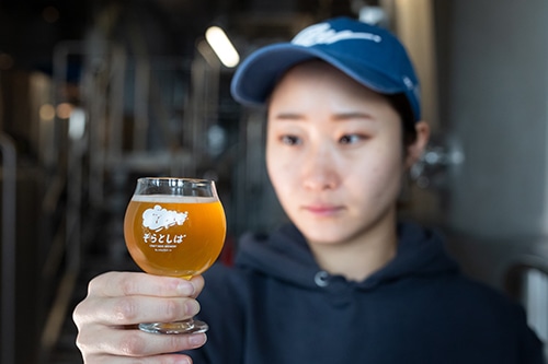 グラス入ったクラフトビールをブルワー(ビール醸造士)が眺めている画像