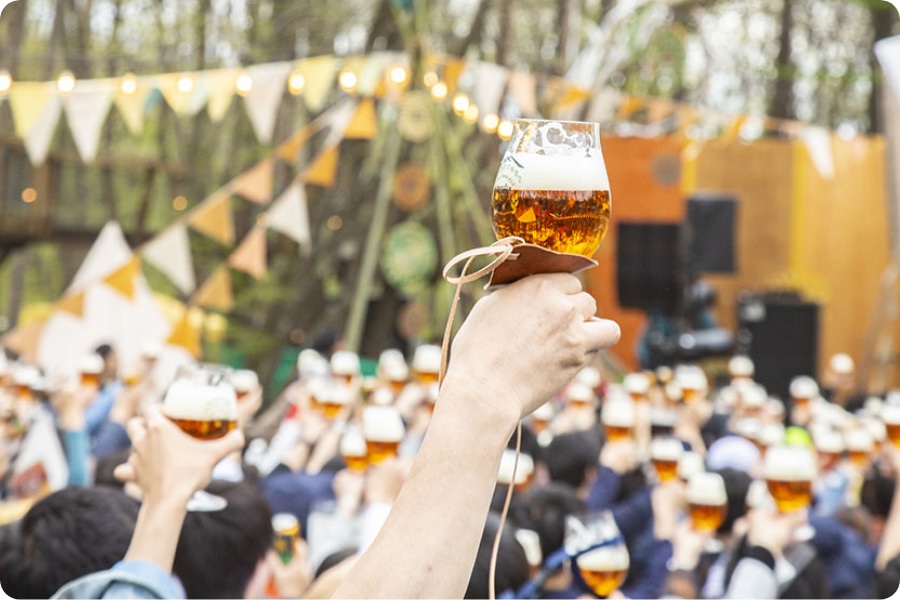 クラフトビールのイベントで大勢の参加者がグラスを掲げて一緒に乾杯している画像